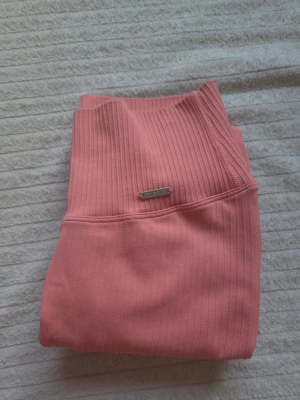 🩷Rosa seamless tights från Aim'n🩷 - Säljer ett par superfina ribbade seamless tights i en härlig rosa/korall nyans (svårt att få till färgen helt) 🩷                                                                    Hög midja och stretchigt material som sitter väldigt fint. Endast använda 1 gång och i mycket fint skick✨️                                                                 ⚠️ OBS: Jag granskar alla plagg noga innan försäljning, men mindre skavanker kan missas. Allt säljs därför i befintligt skick enligt bilderna.