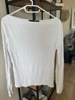 Vit långärmad topp från 157 - En enkel och stilren vit långärmad topp från 157. Toppen har en rund halsringning och är gjord i mjuk bomull, perfekt att matcha med jeans eller kjol. Passformen är normal och materialet känns skönt mot huden.