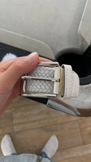 Vitt flätat bälte  - Helt nytt aldrig använt men jag råkade beställa fel färg. Snyggt vitt bälte med flätad design och silverspänne. Bältet har detaljer i ljust skinn och passar perfekt till jeans eller chinos. Enkel och stilren look som lyfter outfiten.
