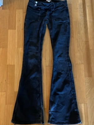 Svarta bootcut jeans - Svarta lågmidjade jeans från gina i modell TALL och långa på mig som är 167/168. Slitna längst ner vid benet.