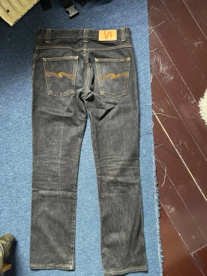 Nudie Jeans - Då taggen är washed out vet jag ej vilken modell det är på jeansen, men jag skulle gissa på ett par thin finn. Midjan är ungefär 29, och längden är 30. Fina honeycomb-fades och inga hål eller liknande!