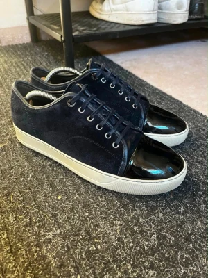 Lanvin skor - Säljer nu dessa snygga mörblåa mocka Lanvin cap toe som är i mycket bra skick skulek säga mellan 8-9/10. De är äkta såklart vid snabb affär så kan jag tänka mig gå ner till 1800kr. Flera frågor så är det bara att fråga.