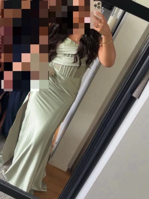 Ljusgrön långklänning i satin - Säljer min jätte fina balklänning. Endast använd 1 gång. Jag har klippt bort underkjolen då den var för kort men de är ingen skillnad på något annat. Den är skön och perfekt om man vill kunna vara rörlig men också ha en tajt och fin klänning. Köpte den för 950 kr.