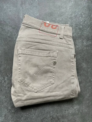 Dondup George jeans  - Tjena, säljer nu dessa riktigt snygga och populära dondup George jeansen i bra skick, de är en grå/khaki färg, storlek 30, mått finns på bilden, hör av er vid frågor och funderingar🙌🤝 