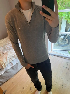 Grå stickad quarter zip från Tommy Hilfiger - Snygg Tommy Hilfiger tröja  i storlek M.                    Nypris ca 2500kr                                                                 Pima Cotton blend