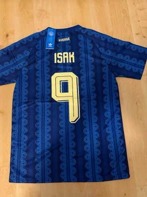 Isak #9 – Sverige Borta (storlek S) - Isak #9-tryck. Sverige Borta (blå). Storlek S. Helt ny och aldrig använd. Skickas snabbt 🚚💨  Mått (S): Halvt bröstmått 51 cm • Längd 72 cm • Ärmbredd 22 cm • Axelbredd 42 cm • Ärmlängd 39 cm • Manschett 18 cm.  🔥 Fan Edition – normal passform. 🇸🇪 Sverige landslag.  📩 Frågor eller prisförslag? Skicka gärna ett meddelande! 🛍 Bundle-rabatt upp till 20% 💰 📦 Skickas samma eller nästa dag 🌟