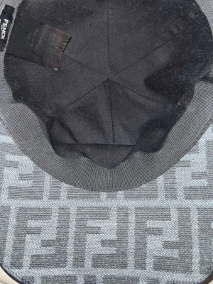 Fendi keps med FF-mönster - Snygg keps från Fendi med det klassiska FF-logomönstret i grått och svart. Kepsen har böjd skärm med mörk kant och är tillverkad i textilmaterial. Perfekt accessoar för att lyfta din outfit.