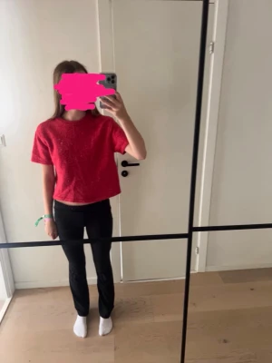 Röd stickad t-shirt - Säljer en röd stickad t-shirt med korta ärmar och rund hals. T-shirten har en enkel och avslappnad passform, perfekt till jeans eller byxor. Materialet känns mjukt och bekvämt mot huden.
