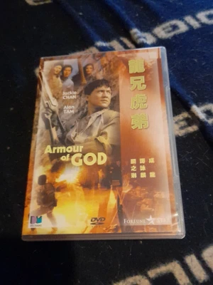 DVD Armour of God Jackie Chan - DVD-film Armour of God med Jackie Chan och Alan Tam. Omslaget har både engelska och kinesiska texter, med actionfyllda bilder i gult och orange. Perfekt för dig som gillar klassiska actionfilmer.