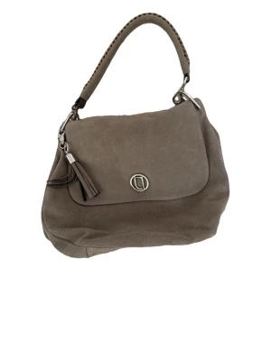 Taupe axelremsväska med tofsdetalj - Snygg taupe handväska från Coccinelle i mjukt mockaliknande material. Väskan har ett lock med silverfärgad logga och en dekorativ tofs. Kort axelrem med flätad detalj och stilren, rundad form. Perfekt för dig som gillar klassisk men trendig design.