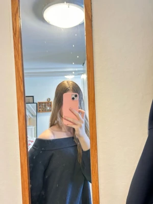 Mörkgrå off shoulder stickad tröja - Säljer en mörkgrå stickad tröja med bred off shoulder-krage. Tröjan har en avslappnad passform och långa ärmar, perfekt för en chill och stilren look. 