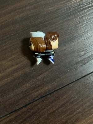 Mini Funko Pop figur, sjömansdräkt - Säljer en liten Funko Pop-inspirerad figur med brunt hår och vit sjömanshatt. Figuren har svart och vit dräkt med blå detaljer och stora svarta ögon. Perfekt som dekoration eller samlarpryl för dig som gillar unika minifigurer.