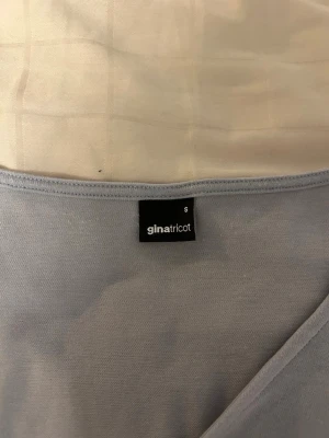 Ljusblå långärmad topp Gina Tricot - Säljer en ljusblå långärmad topp från Gina Tricot. Toppen har en enkel och stilren design med rund halsringning och mjukt material som känns skönt mot huden. Perfekt att matcha med jeans eller kjol för en clean look.