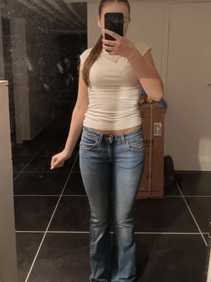 Blå bootcut jeans med låg midja - Snygga blå bootcut jeans med låg midja. Jeansen sitter tajt över låren för att sedan bli vidare nedtill. Perfekta för en avslappnad och trendig stil. Har bara används 1 gång. Pris kan discuteras💗