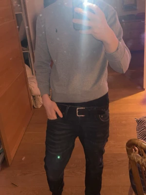 Mörkblå slim fit jeans - Säljer ett par mörkblå slim fit jeans med klassisk femficksdesign och svarta sömmar. Jeansen har en snygg tvättad look och sitter tajt över benen för en modern stil. Perfekta till både hoodie och t-shirt.