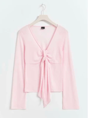 Ljusrosa långärmad topp med knyt - Söt ljusrosa långärmad topp från Monki med v-ringning och knyt framtill. Toppen har en croppad passform och är tillverkad i mjuk bomullsmix. Perfekt för dig som gillar en feminin och trendig stil. Ser mycket mer livlig ut i verkligheten än på bilden. Använt 1 gång men den va för stor och säljet på grund av denna anledning💕💕