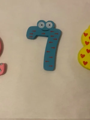 Färgglada magnetiska siffror i trä - Säljer ett set med färgglada magnetiska siffror i trä, perfekta för kylskåpet eller whiteboarden. Siffrorna har olika färger och mönster, som hjärtan, trianglar och pilar, samt ögon för en lekfull look. Passar bra för att lära sig siffror eller dekorera. Finns 0-9 kvar , 35kr/3st / bild , helt ny 
