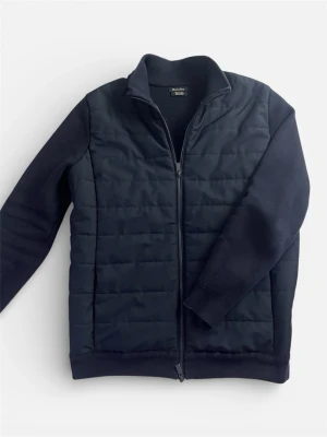 Mörkblå quiltad cardiganjacka - Snygg mörkblå cardiganjacka från Massimo Dutti med quiltad front och mjuka stickade ärmar. Jackan har dragkedja hela vägen, ståkrage och en stilren look som passar perfekt till jeans. Materialet är en mix av vadderad polyester och stickad bomull.