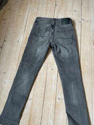 Slim glen  - Snygga grå jeans med slim passform och klassisk femficksdesign. Jeansen har en tvättad look och svarta sömmar, med vanligt jeans material. Storlek=28W 30L. Priset är ej hugget i sten och kontakta gärna vid minsta fråga 🫡👍