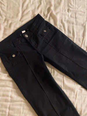 Svarta lågmidjade jeans  - Svarta jeans med detaljer från hm. Slutsålda. Storlek 34