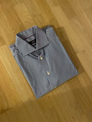 Randig skjorta från Eton, blå/röd - Snygg skjorta från Eton i contemporary fit. Nypris ca 1700kr mitt pris endast 199 kr. Fraktar inom 1 dag, om du har någon fundering så är det bara att höra av sig😊