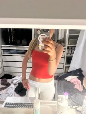 Röd croppad linnetopp - Snygg röd croppad linnetopp med smala axelband. Perfekt för varma dagar och enkel att matcha med både jeans och kjol. Toppens material känns mjukt och stretchigt, vilket ger en bekväm passform.