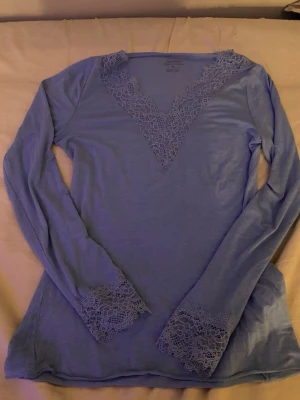 Spets tröja från Intimissimi - Mysig blå långärmad loungewear-tröja från Intimissimi i kashmir. V-ringad med spetsdetaljer vid halsringning och ärmslut som ger en extra touch. Bara använd 1 gång. Kan tänka mig att gå ner i pris vid snabb affär.