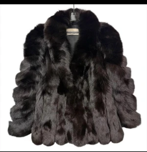 Svart lyxig pälsjacka - Säljer en svart pälsjacka i rävpäls från saga furs. Jackan har bred krage.  Storlek S men passar även M. Längd 73cm