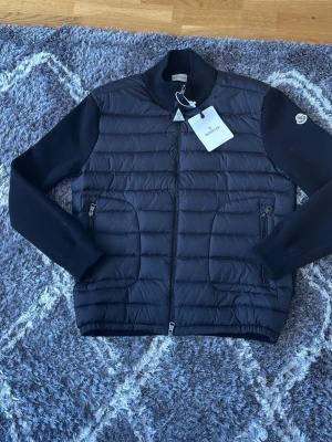 Moncler Cardigan Svart - En Moncler cardigan i Storlek XXL som är M och L perfekt för våren, helt ny tags alltin förekommer, har även nfc