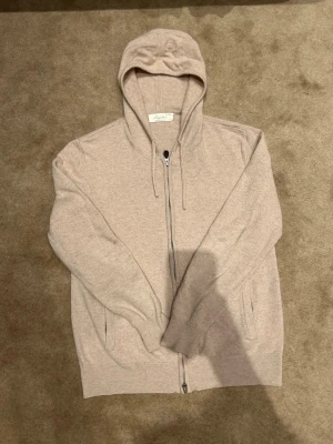 Beige zip-hoodie från Sayless - Mysig beige zip-hoodie från Sayless i mjuk kashmir. Hoodien har dragkedja framtill, två fickor och justerbar huva med snören. Pris kan diskuteras!! Vid minsta fundering är det bara att höra av sig!