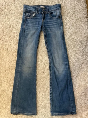 Blå bootcut jeans med slitningar - Snygga blå bootcut jeans med lätt slitna detaljer och klassisk femficksmodell. Jeansen har en något utsvängd passform nedtill och är gjorda i mjukt denimtyg. Perfekta för en avslappnad och trendig look.💕💕