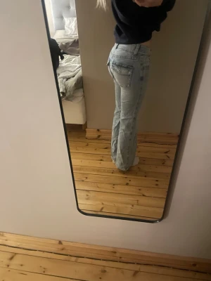 Ljusblå raka jeans med låg midja - Säljer ett par ljusblå jeans med rak passform och låg midja. Jeansen har klassiska fem fickor och stängs med dragkedja och knapp. Perfekta för en avslappnad och trendig look. Materialet är denim i bomull.