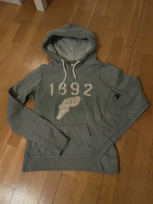 Abercrombie & Fitch Hoodie - Snygg hoodie i bra skick, lite slitage på trycket men det ger den mer charm💖 Mycket liten i storlek skulle säga att den passar en XS/S😇