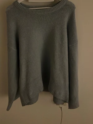 blå oversized stickad tröja - Mysig blå stickad tröja med oversized passform och rund halsringning. Tröjan har långa ärmar och ribbade detaljer vid ärmslut och nederkant. Perfekt för lager på lager och chill dagar.