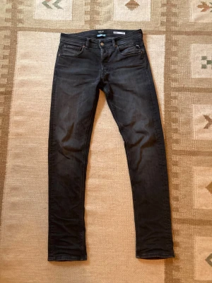 Replay Grover  - Säljer ett par svarta jeans från Replay, modell Grover Straight Fit. Jeansen har klassisk femficksdesign, snygga detaljer och är tillverkade i hållbart denim-material. Perfekt för dig som gillar en rak passform och stilren look. W30 L34. Bara att skriva vid frågor!
