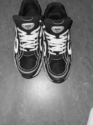 Dior B30 - Snygga svarta Dior sneakers med vita detaljer och vita skosnören. Skorna har en chunky sula och meshpaneler för extra ventilation. Skornas låda och dior påse kommer med. Skriv för mer bilder