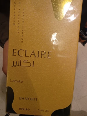 Eclaire Banoffi parfym 100ml Lattafa - Eclaire Banoffi från Lattafa är en parfym i en lyxig guldfärgad förpackning med eleganta detaljer. Flaskan rymmer 100 ml och har en modern design. Perfekt för dig som gillar unika och exklusiva dofter.