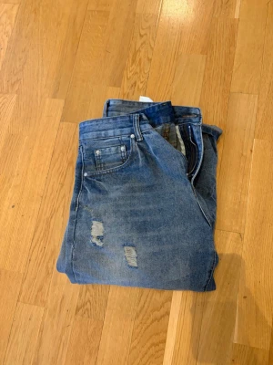 Vintage Wash Jeans - Säljer ett par helt nya bootcut jeans ( använda två gånger ) från piecesoflifestudio. Ett ”tiktokföretag” som börjat sälja shyssta jeans. Rekommenderar att ni går in på deras TikTok ”piecesoflifestudio” för att se hur byxorna är tänk att sitta. Jeansen har shyssta slitningar på låren och lite olika slags färger på sömmarna. Jeansen har klassisk femficksdesign och dragkedjegylf. Storlekarna är W31 & L32.                                  Nypris 539kr. Pris kan diskuteras vid snabb affär🙂