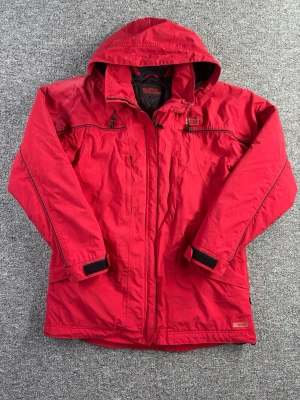 Fjällräven jacka M röd – funktionell outdoor - Röd jacka från Fjällräven i storlek M. Praktisk och funktionell modell med huva och flera fickor – perfekt för friluftsliv och vardag.  📏 Storlek: M 📐 Mått visas i bilderna ✨ Skick: Fint skick. Något solblekt på vissa partier, vilket visas tydligt i bilderna.  Perfekt som vår-, höst- eller fritidsjacka.  💸 Följ mig så får du 10% rabatt på köpet!