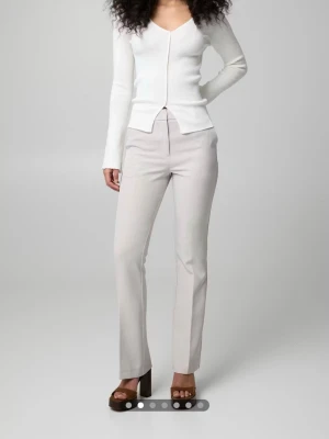 Ljusbeige raka kostymbyxor - Snygga ljusbeige kostymbyxor med rak passform och pressveck. Byxorna har hög midja och diskreta fickor i sidorna. Perfekta för en stilren och modern look. Materialet ser ut att vara en mjuk och lätt vävd textil.