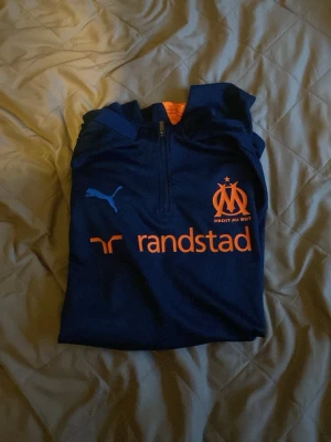 Olympique De Marseille långtröja 24/25 - Tunn mörkblå, ljusblå och orange långtröja från fotbollslaget olympique Marseille! Puma!