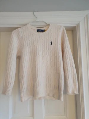 Kabelstickad tröja Polo Ralph Lauren -  Jag säljer nu denna snygga kabelstickade tröjan från Polo Ralph Lauren pga den var för liten för mig. Tröjan är snygg och väldigt bekväm och har mycket stretch i tyget. När jag köpte den på Plick hade den fortfarande lappen kvar så tröjan är väldigt ny och fräsch och inga skavanker.