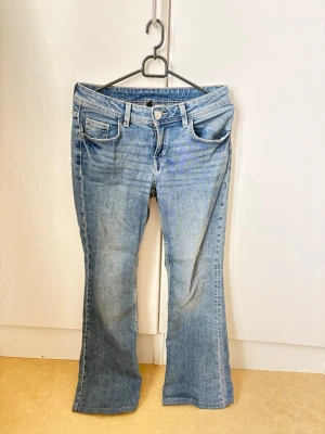 Bootcut ljusblå jeans med låg midja - Snygga ljusblå bootcut jeans med låg midja och klassiska fem fickor. Jeansen har en lätt tvättad look. Passar xs-s.Använd ca 2 gånger, inga defekter. Skriv vid funderingar 