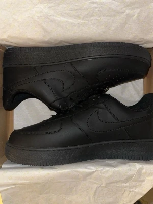 Nike Air Force 1 Triple Black  - Säljer ett par Nike Air Force 1 i helsvart (Triple Black). Helt nya och oanvända, endast testade inomhus.  • Storlek: 45 (EU) • Skick: 10/10 – helt nya • Färg: Svart • Originalbox ingår  Riktigt clean modell som passar till allt. Perfekta både till vardag och streetwear.  Säljs billigt för snabb affär. Först till kvarn. Kan skickas direkt eller mötas upp.  Skriv vid seriöst intresse 🔥