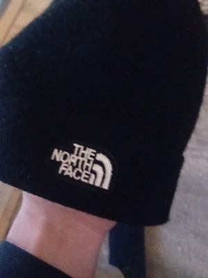 Svart mössa från The North Face - Säljer en svart mössa från The North Face och jag köpte den för 350 och den är 1 vecka gammal jag skulle ge dem till min lille bror som present men han ville inte ha den så nu bjuder jag mössan för 250 kronor 