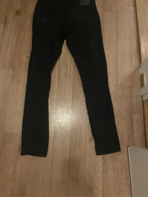 Svarta skinny jeans från 157 - Säljer ett par svarta skinny jeans från lager 157med klassisk femficksmodell och knappgylf.  Den är i jätte bra skick helt ny asså. Jeansen har smal passform och är perfekta till en avslappnad streetstil. Materialet känns stretchigt och bekvämt för vardagsbruk.