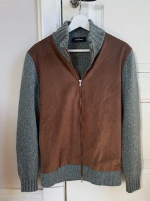 Gran Sasso Cashmere Cardigan - Nu säljer vi denna sällsynta och riktigt fina Gran Sasso cardigan gjord i Cashmere och brun suede. Storlek 50, som passar M. Skicket är 10/10 och inga defekter finns. Nypris på ca 7000 kr, och vi säljer för ett mycket billigare pris än det!