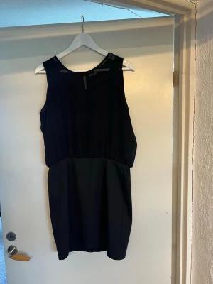 Svart ärmlös kortklänning från Only - En stilren svart ärmlös klänning med rund halsringning och rak passform. Klänningen har en enkel design utan synliga detaljer och passar perfekt för dig som gillar minimalistisk stil.