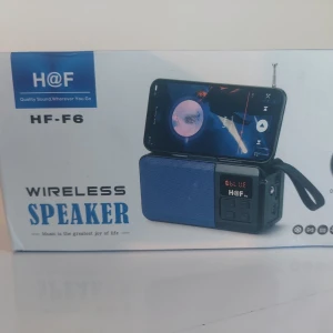 Trådlös högtalare med solpanel och ficklampa - Trådlös bärbar högtalare från H@F, modell F6. Högtalaren är svart med blå front, har en rektangulär form och är tillverkad i plast och metall. Utrustad med display, knappar och handrem för enkel transport. Perfekt för streaming och musikuppspelning.
