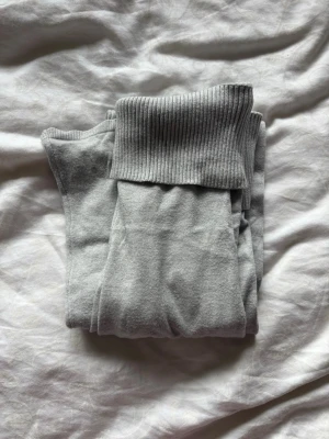 Grå stickade yogapants - Gråa mjukisbyxor från SAMSA Young med breda ribbade muddar i midjan och benslut. Byxorna är i mjukt och bekvämt material, perfekta för chill dagar. Klassisk passform och neutral färg som funkar till det mesta.